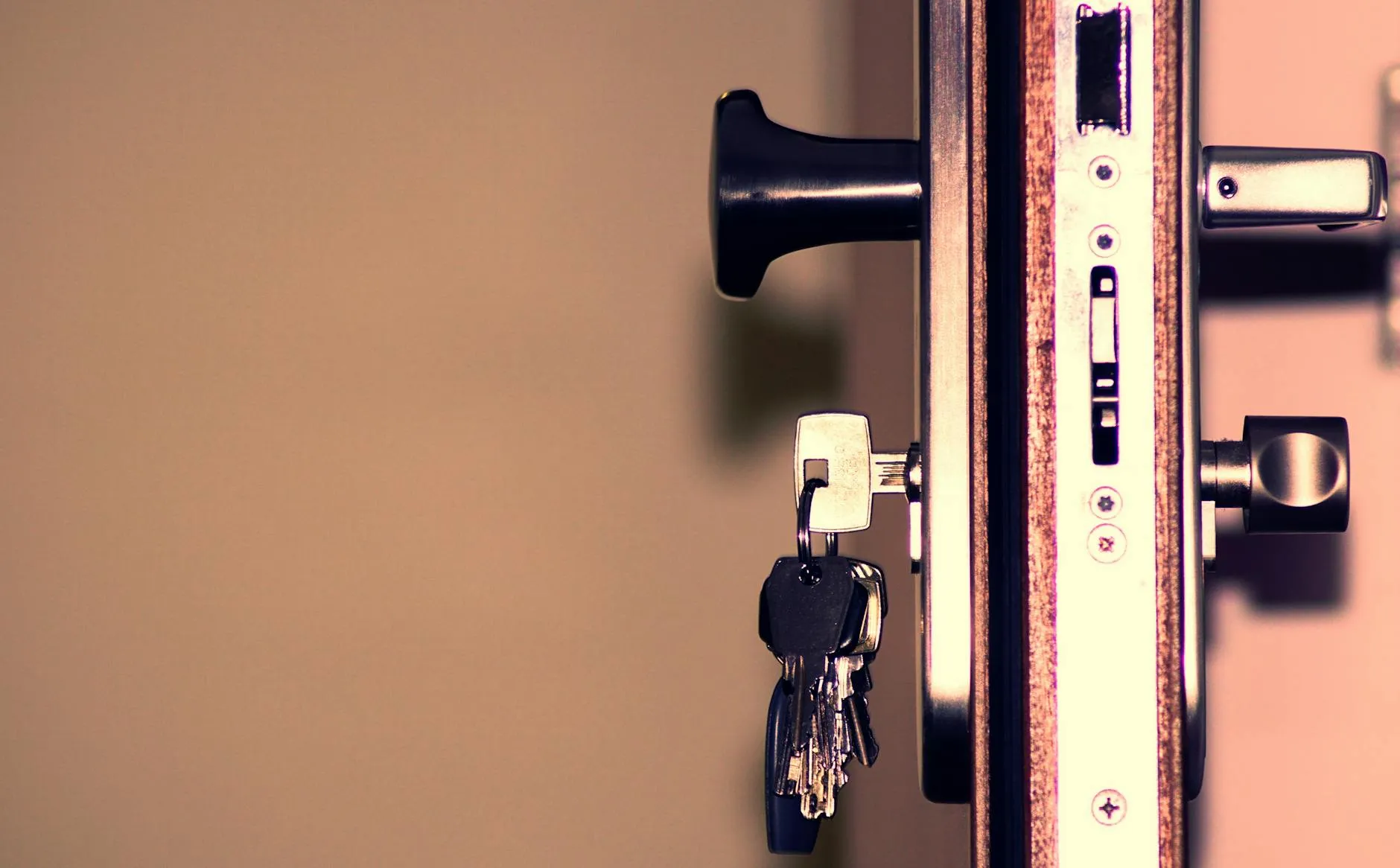 A locksmith working on a residential door lock