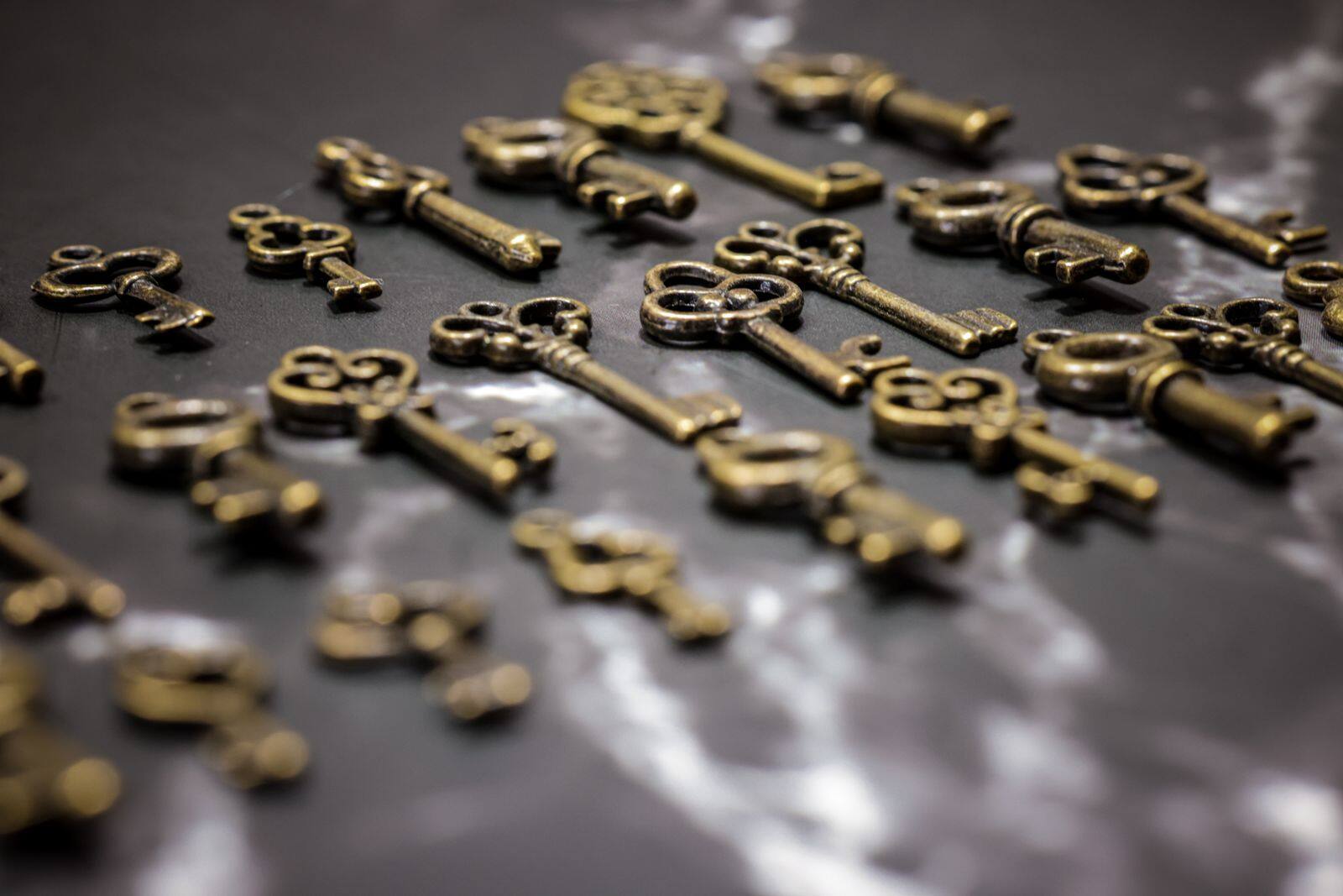 Vintage brass keys scattered on a dark surface
