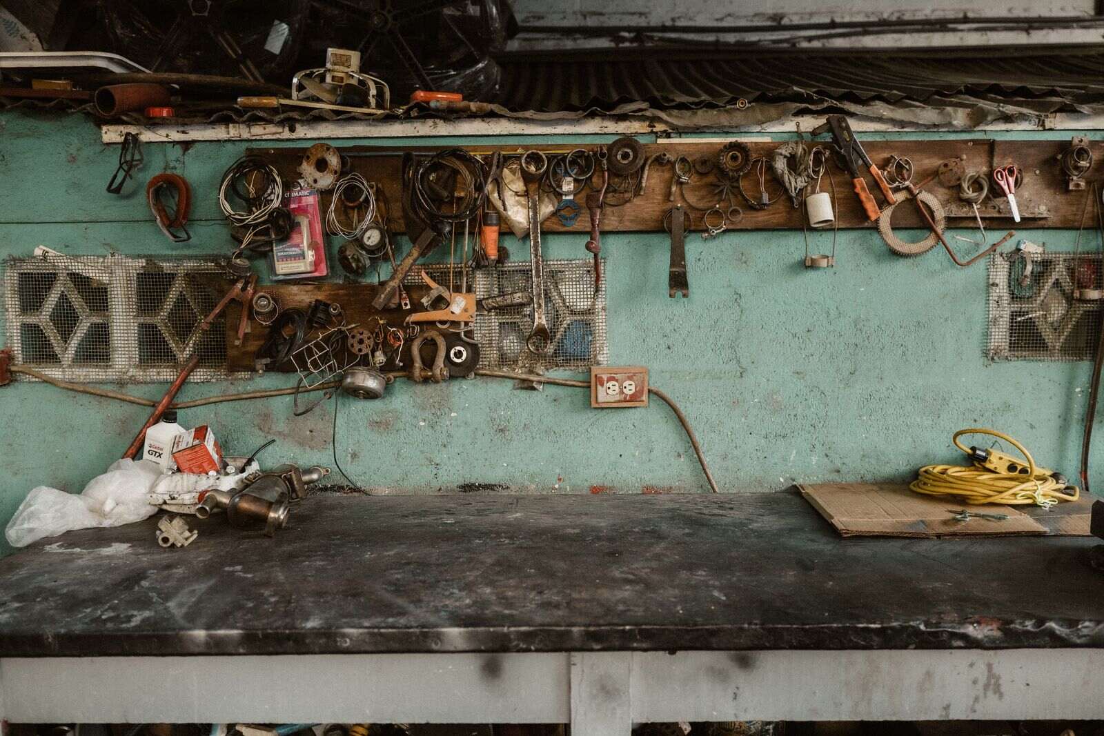 Well used hand tools hanging above a workshop bench